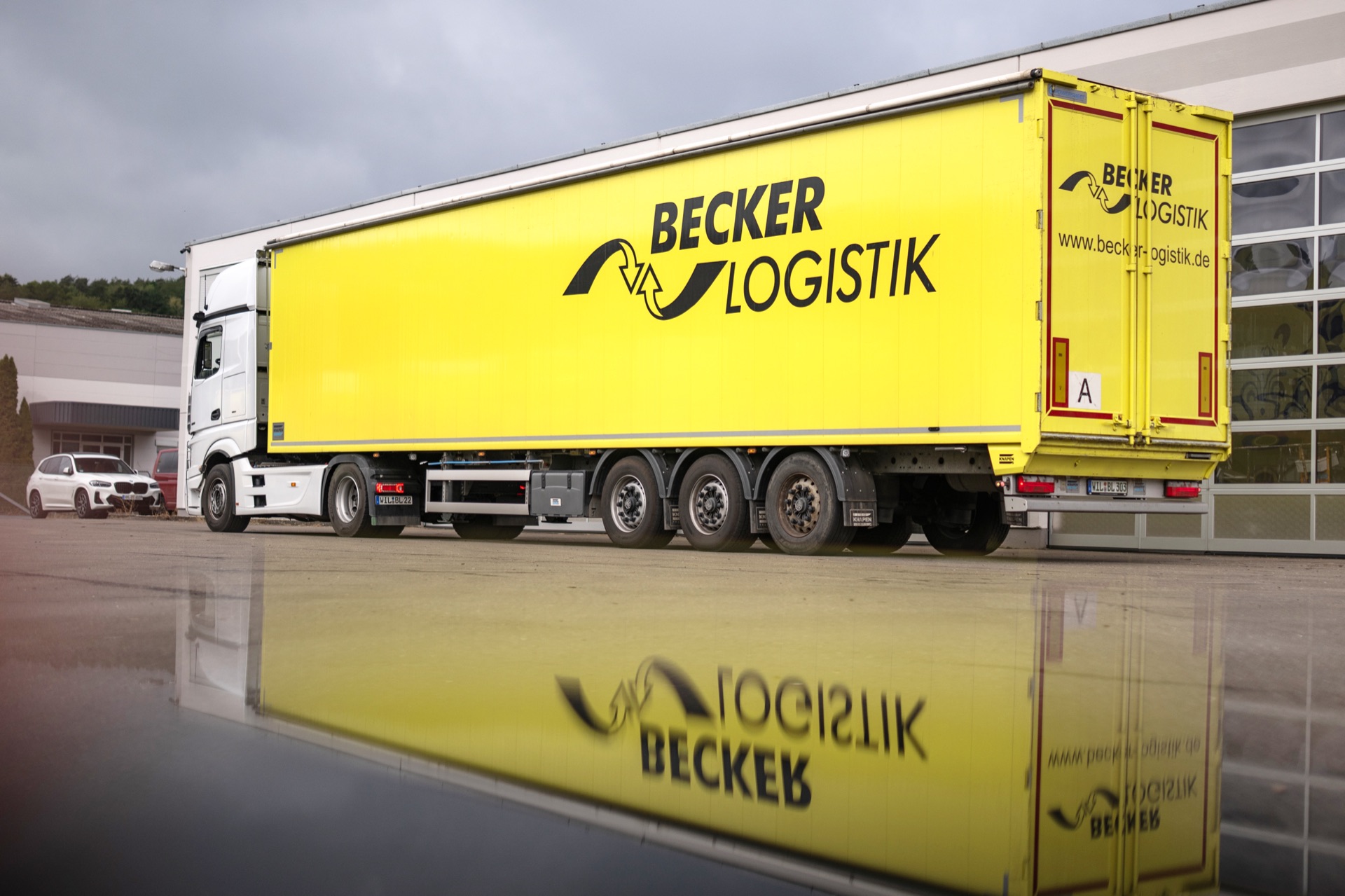 Gelber Becker-Logistik-Trailer mit Firmenlogo